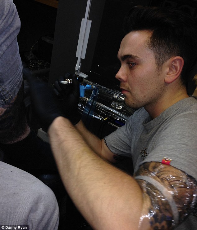 Inking: TV star Ray concentrates as he signs his name on the tattooist's leg