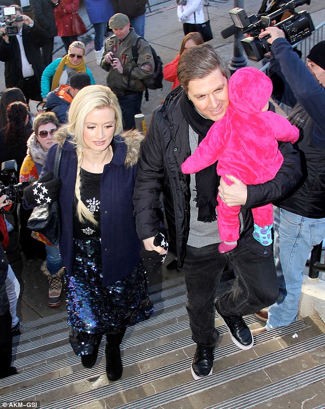 Coming through: The couple held hands as they navigated through the crowd, with Holly looking distressed