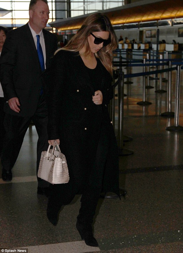 Natural stunner: Kim looked gorgeous beneath dark sunglasses and an oversized trench coat