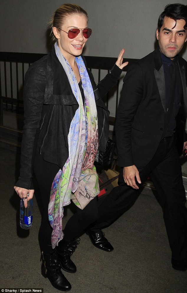 Comfort: The singer wore a colourful flowing scarf as she made her way through the airport