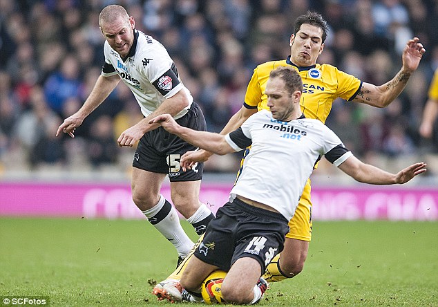 Committed: Brighton's Leonardo Ulloa is tackled by Derby's John Eustace with both knees taking possession