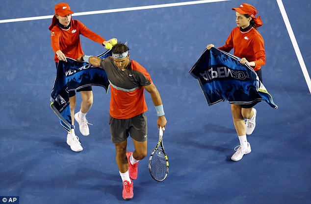 Sweaty work: Nadal towels off after winning a point though temperatures have cooled in Melbourne since the sweltering conditions at the start of the week