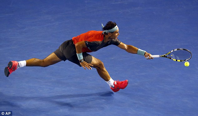 On the stretch: Nadal reaches to make a forehand return against Monfils as he set up a fourth round date with Japan's Kai Nishikori