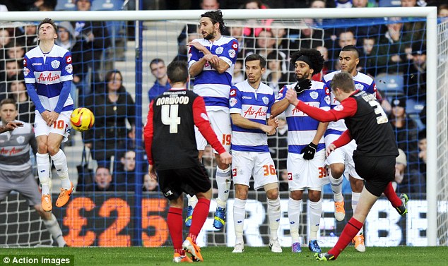 Don't look now: Huddersfield's Paul Dixon blasts a free kick into QPR's Tom Carroll