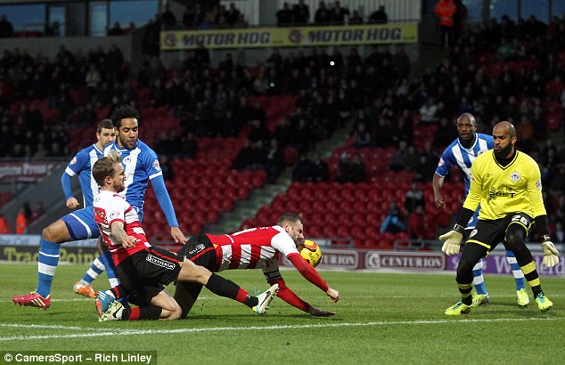 Bizarre: Coppinger (left) was credited with the second despite a strange deflection off Richie Wellens (centre)