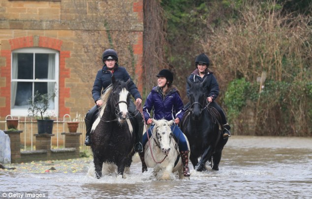 Preventable: People ride horses through flood water near Langport in Somerset, England during this month's flash-flooding