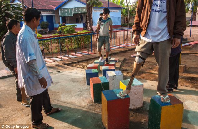 Exercise: A staff member supervises a training session in which these amputees can learn to move confidently using their prosthetics