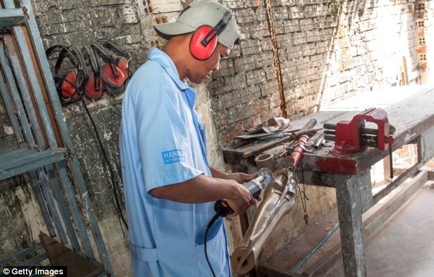 Crafting: A Handicap International worker helps to build a prosthetic limb at the rehabilitation centre