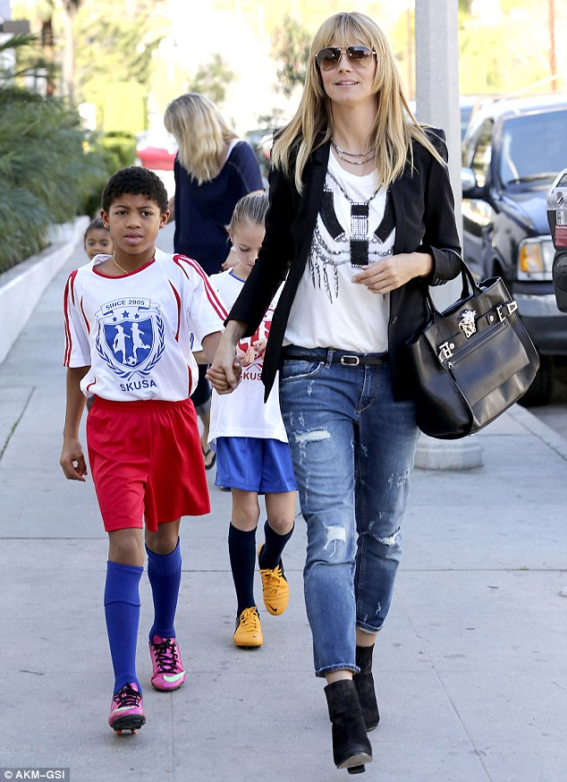 Hand in hand: Heidi gripped her eldest son Henry's hand as the family braved the warm LA day