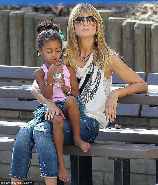 Staying hydrated: Lou sipped from a bottle of water as she sat on her doting mother's lap