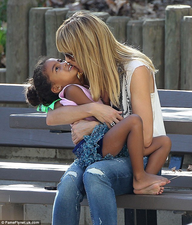 Kisses! The German stunner showered her little one with love as they sat on a park bench