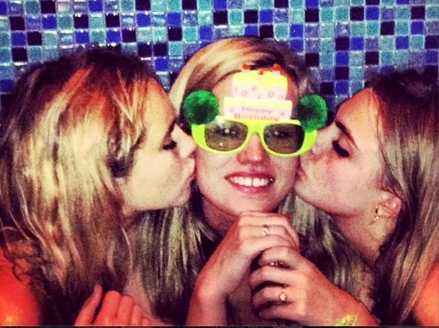 Centre of attention: The birthday girl gets celebratory kisses from Suki Waterhouse and Cara