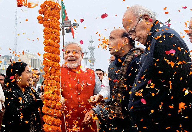 BJP PM candidate Narendra Modi hoists the party flag as president Rajnath Singh, senior leaders LK Advani and Sushma Swaraj look on during the National Council meet in Delhi on Saturday