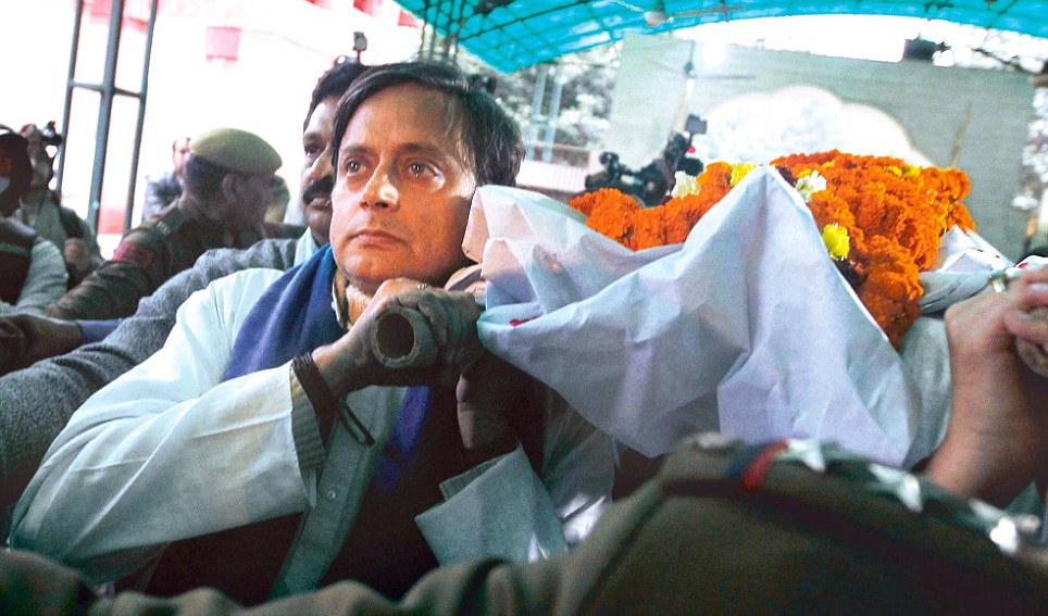 With
eyes brimming
with tears, Shashi
Tharoor
carries the bier