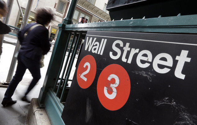 FILE - In this Oct. 2, 2014 file photo, people pass a Wall Street subway stop, in New York's Financial District. U.S. stocks are opening moderately lower Tue...