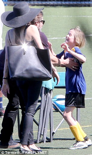 Doting daddy! After the parents walked out on the field, Shiloh enthusiastically jumped in Brad's arms