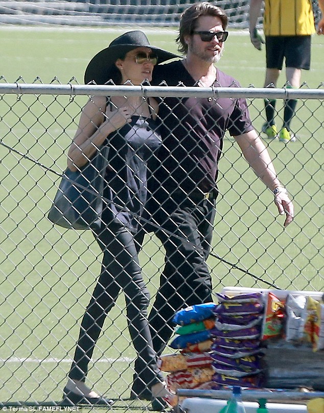 Leisurely stroll: Brad affectionately had his arm wrapped around his ladylove as they strolled side-by-side while walking off the pitch