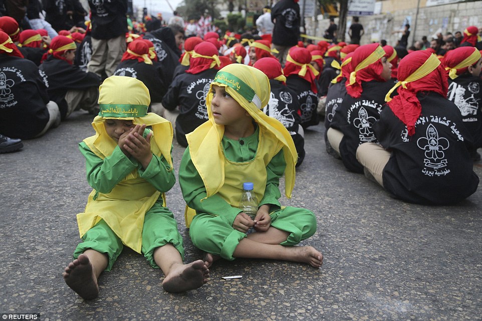 Lebanon's Hezbollah scouts sit on the ground as they take part in a religious procession to mark Ashura in Beirut's suburbs