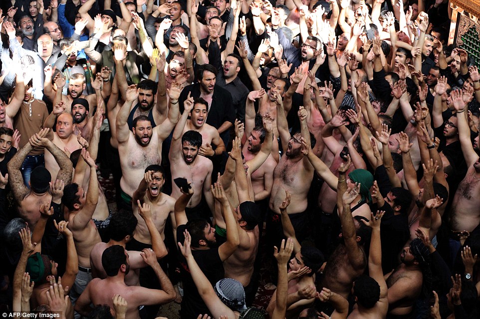 Iranian and Iraqi Shiite Muslims beat themselves during a ritual at Tehran's Karbalaiya Mosque