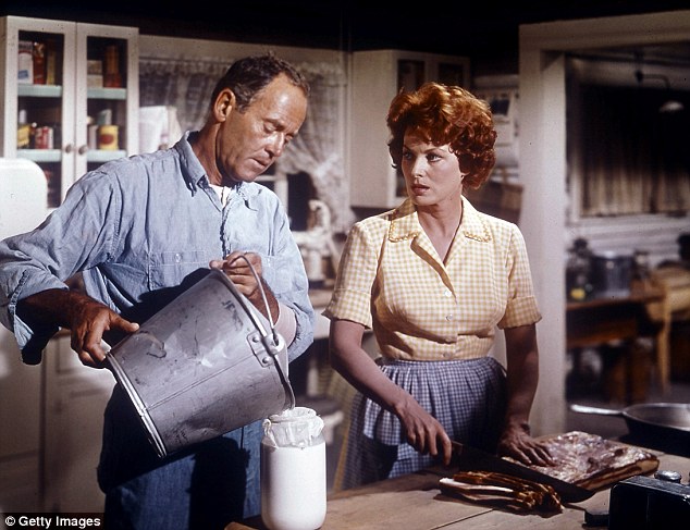 Henry Fonda helps Maureen O'Hara in the kitchen in a scene from the film Spencer's Mountain, 1963