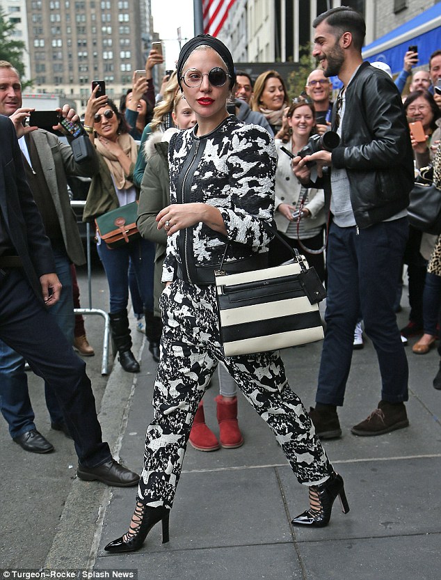 Standing out: She teamed the outlandish and eye-catching ensemble with strappy high heels and carried her belongings in a monochrome handbag