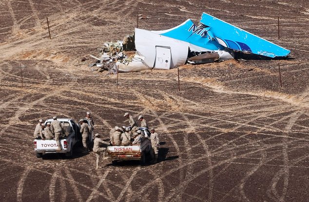 In this photo made available Monday, Nov. 2, 2015, and provided by Russian Emergency Situations Ministry, Egyptian Military on cars approach a plane's tail a...