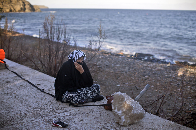 A women rests at a beach after she disembarked from a small boat on the northern shore of Lesbos, Greece, Monday, Nov. 2, 2015. The number of smuggling boats...