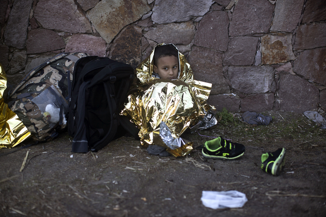 A child wrapped in an emergency blanket rests after disembarking from a small boat on the northern shore of Lesbos, Greece, Monday, Nov. 2, 2015. The number ...