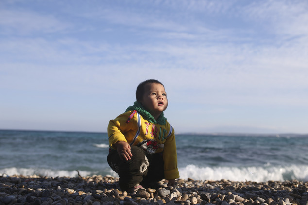 A migrant child passes time on the beach as its family consider their options to begin their effort on dinghies to try to cross from the Turkish coast to the...