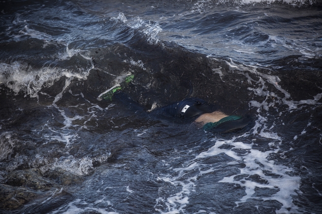 The lifeless body of an unidentified woman is seen floating in a pool of water after washing up on the shoreline at the village of Skala, on the Greek island...