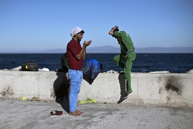 An Iraqi man prays at the port of Mytilene on the island of Lesbos, Greece, Monday, Nov. 2, 2015. More than 300,000 people have traveled on dinghies and boat...