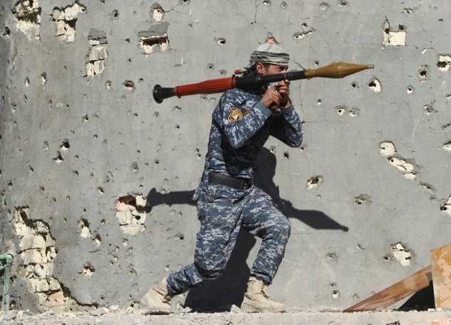 An Iraqi soldier advances on the town of Husayba during a military operation against Islamic State (IS) jihadists on the outskirts of Ramadi, on December 7, ...