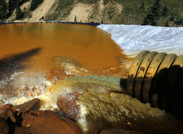 FILE - In this Aug. 14, 2015, file photo, water flows through a series of sediment retention ponds built to reduce heavy metal and chemical contaminants from...