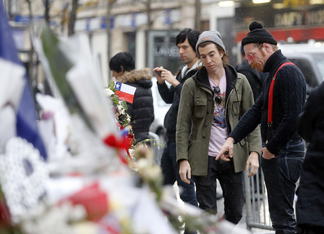 Members of the band Eagles of Death Metal, Jesse Hughes, right, and Julian Dorio pay their respects to 89 victims who died in a Nov. 13 attack at the Batacla...