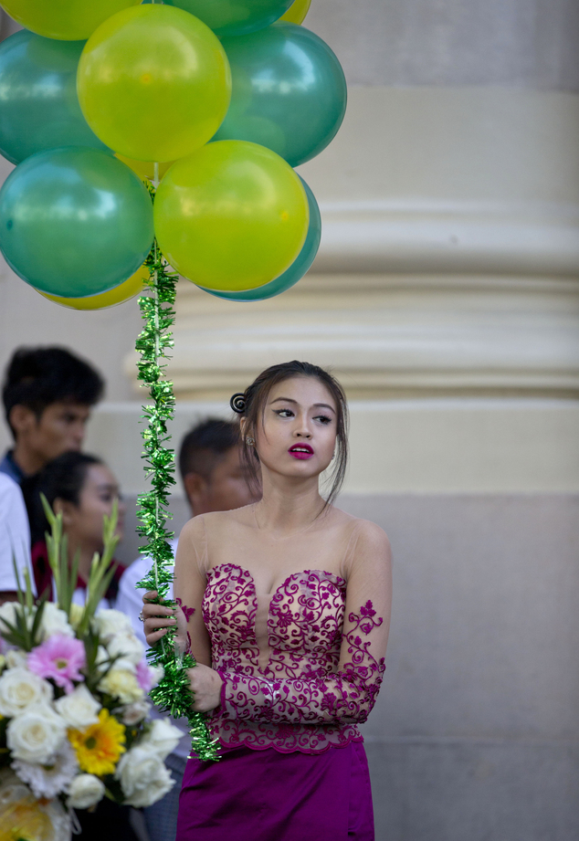 A Myanmar usher holds balloons ahead of the opening ceremony of the Yangon Stock Exchange in Yangon, Myanmar,  Wednesday, Dec. 9, 2015.(AP Photo/ Gemunu Amar...