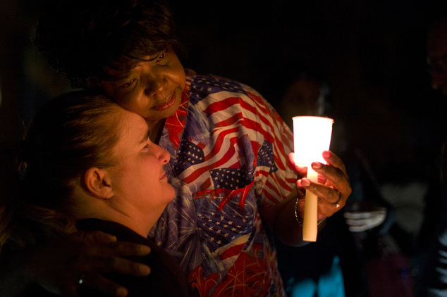 Lisa Hamons, front, a social worker for San Bernardino County, is hugged by Yolanda Richardson during a candlelight vigil for shooting victims on Monday, Dec...