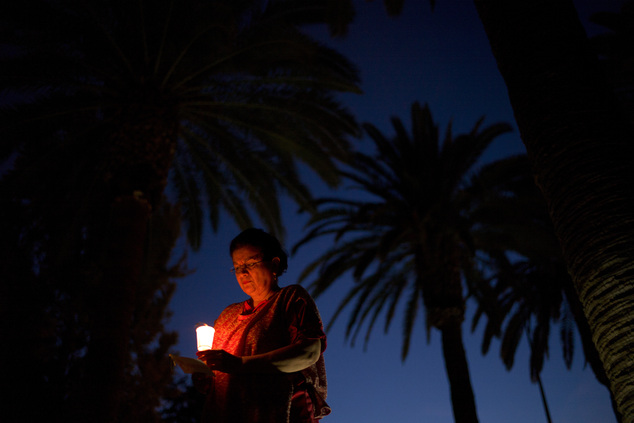 Elvina Guerrero holds a candle during a vigil to honor shooting victims on Monday, Dec. 7, 2015, in San Bernardino, Calif. The husband and wife who opened fi...