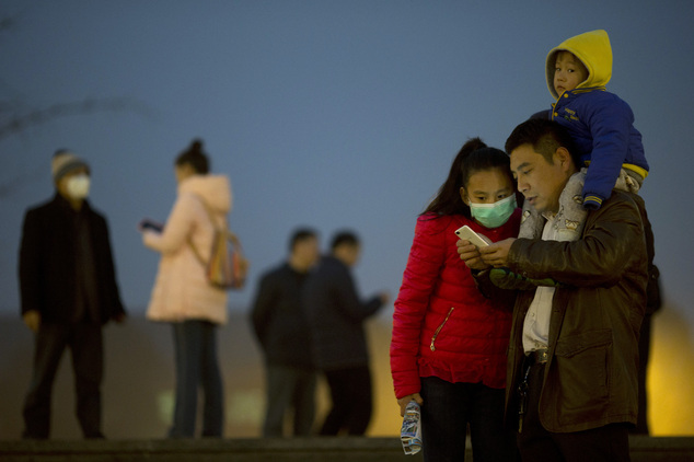 Residents wear masks to protect against the pollution in Beijing, China, Wednesday, Dec. 9, 2015. Unhealthy smog hovered over downtown Beijing as limits on c...