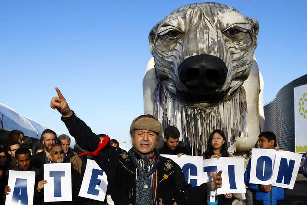 Chief Bill Erasmus of the Dene nation, Northern Canada, center, gestures with activists from Greenpeace during a protest in front of a two-story-high, mechan...