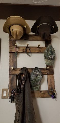 two hats are hanging on a wall with coat hooks and hat hangers attached to it