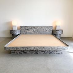 a bed with two candles on each side and an upholstered headboard in the middle