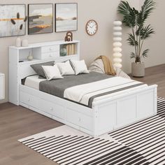 a white bed sitting in a bedroom on top of a hard wood floor next to a rug