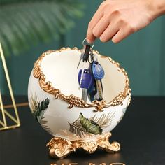 a person is holding scissors in a decorative bowl