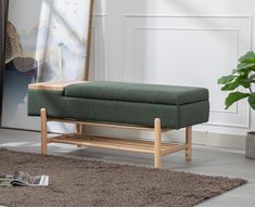 a green bench sitting on top of a rug next to a potted plant in a living room