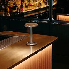 a bar with a metal counter top next to bottles