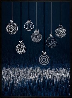 an image of christmas ornaments hanging from strings in the dark night sky with pine trees