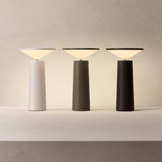 three different colored lamps sitting on top of a table