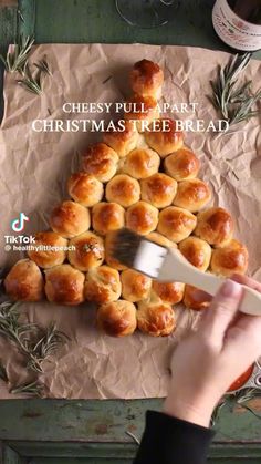 a person is holding a fork near some christmas tree shaped breads on a piece of parchment paper