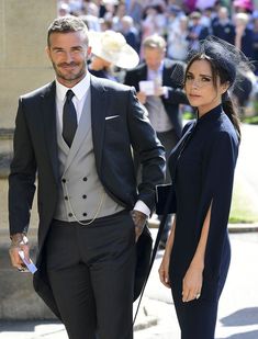 a man in a suit and tie walking next to a woman wearing a black dress