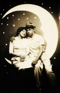 a man and woman sitting next to each other in front of a moon with stars